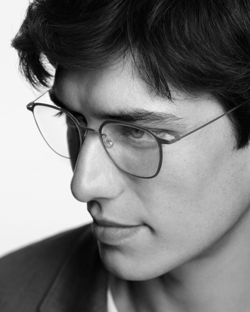 Black-and-white portrait of a young man in slim round LINDBERG wire glasses