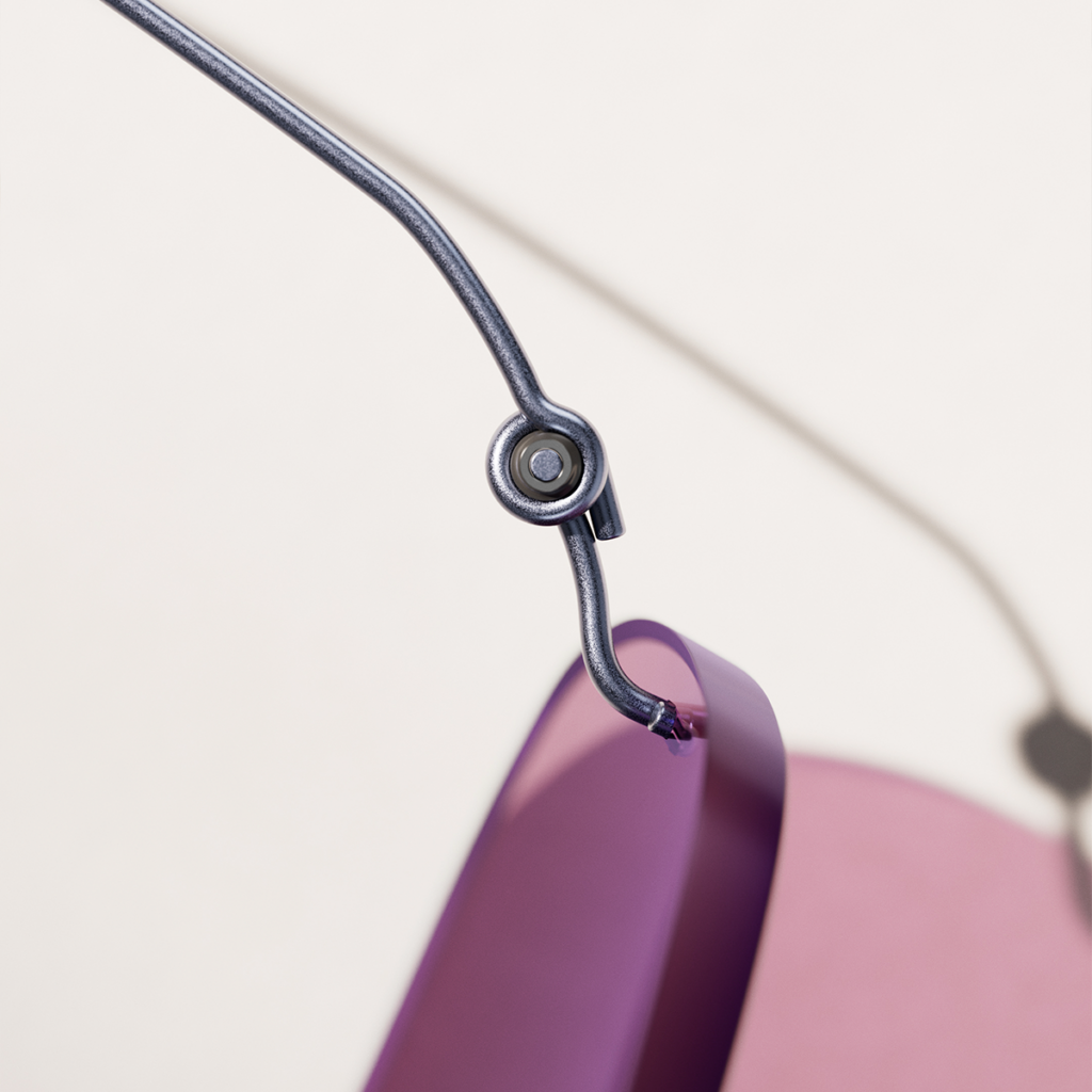 Close-up of a LINDBERG titanium frame joined at the temple with a screwless coil, beside a purple rim