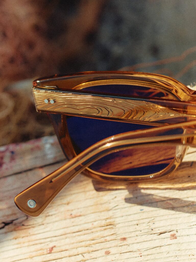 SALT. sunglasses with honey-colored acetate frames resting on weathered wood